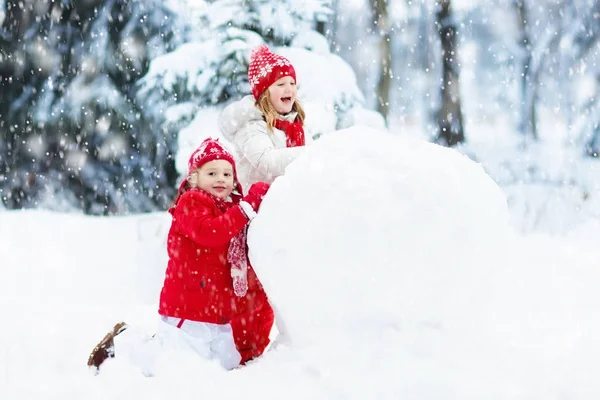 Crianças a construir boneco de neve. Crianças na neve. Diversão de inverno . — Fotografia de Stock