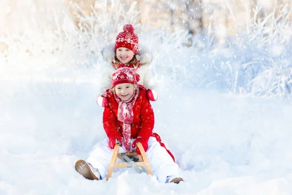 I bambini giocano nella neve. Giro in slitta invernale per bambini — Foto Stock