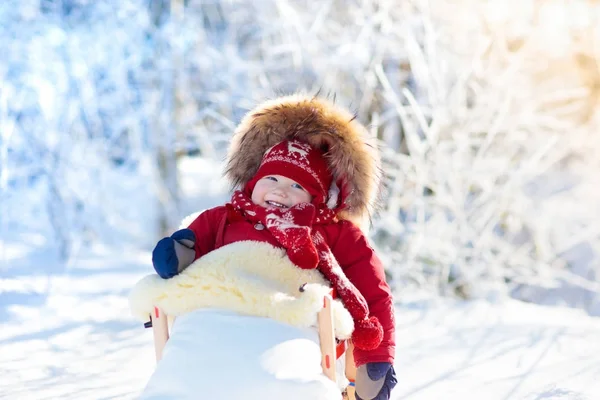 Sled e neve divertido para as crianças. Baby sledding no parque de inverno . — Fotografia de Stock