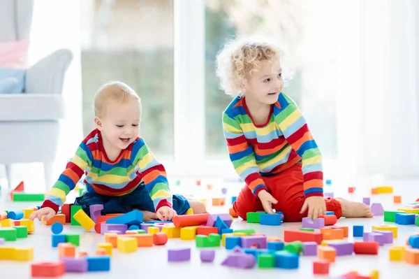 As crianças brincam com blocos de brinquedo. Brinquedos para crianças . — Fotografia de Stock