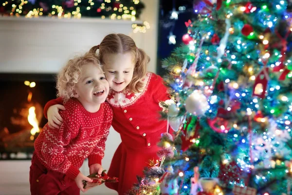 Des enfants au sapin de Noël. Enfants à la cheminée la veille de Noël — Photo
