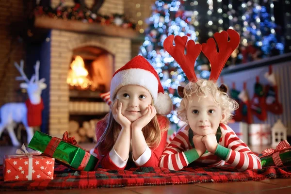 Niño en el árbol de Navidad. Niños en la chimenea en Navidad —  Fotos de Stock