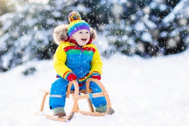 Çocuk kızağı binmek. Kızakla çocuk. Kızak ile çocuk