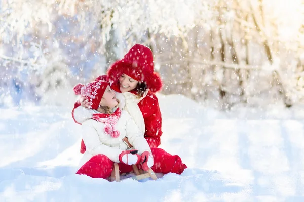 Luge mère et enfant. Amusement hivernal de neige. Famille en traîneau . — Photo