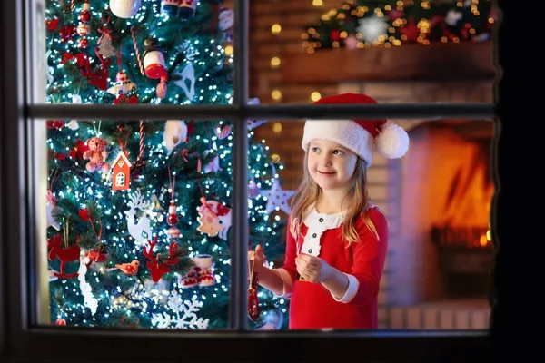 Criança na árvore de Natal e lareira na véspera de Natal — Fotografia de Stock