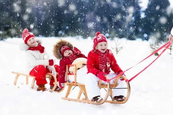Miúdos em trenó. Crianças de trenó. Inverno neve diversão . — Fotografia de Stock