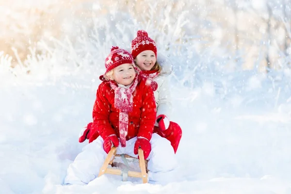 孩子们在雪地里玩。儿童冬季驾雪橇 — 图库照片