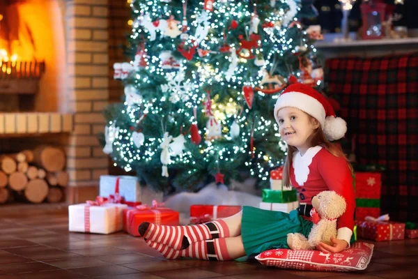 Kind am Weihnachtsbaum. Kind am Kamin an Weihnachten — Stockfoto