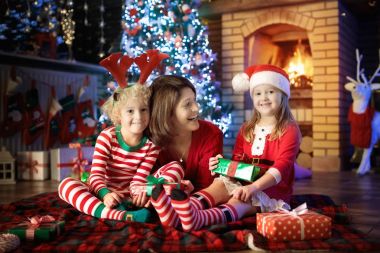 Noel ağacı ve şömine çocuklu aile. 