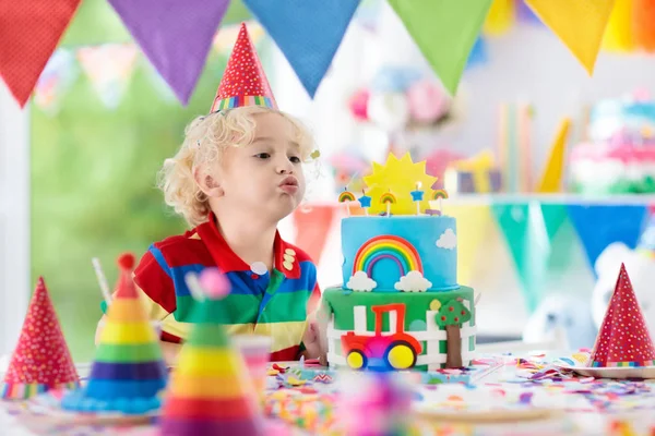 子供の誕生日パーティー。ケーキのろうそくを吹いている子 — ストック写真