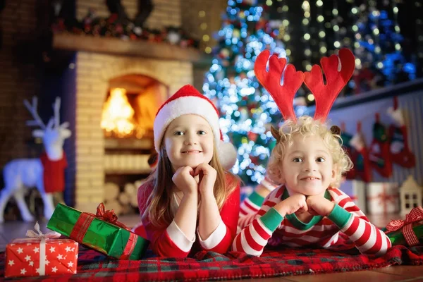 Niño en el árbol de Navidad. Niños en la chimenea en Navidad — Foto de Stock