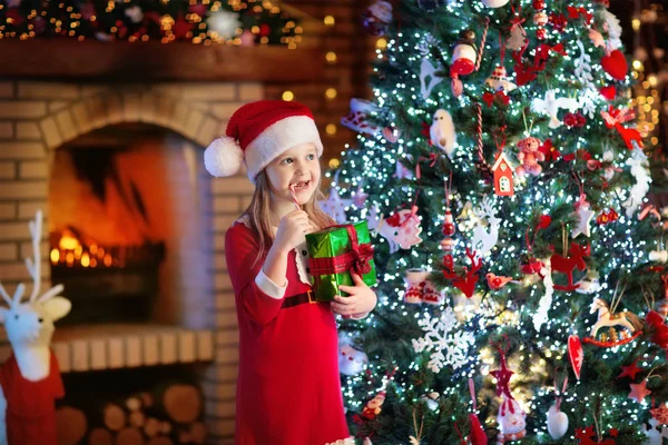 Niño en el árbol de Navidad y chimenea en la víspera de Navidad — Foto de Stock