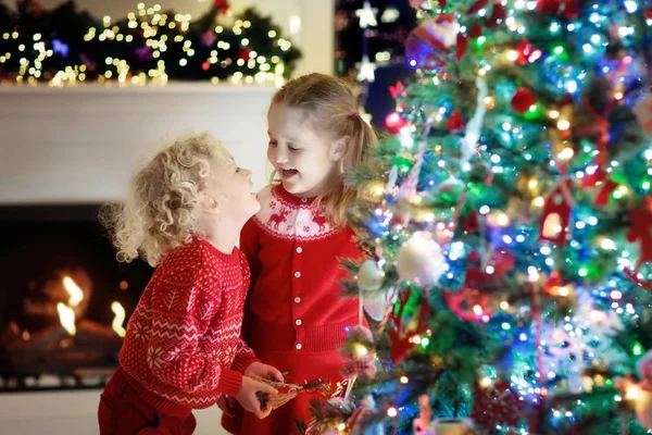 クリスマス ツリーの子どもたち。クリスマス ・ イヴに暖炉のそばで子供たち — ストック写真