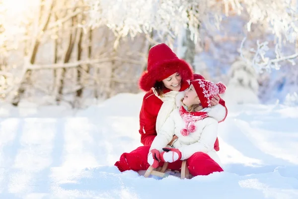 Slitta madre-figlio. Neve invernale divertente. Famiglia sulla slitta . — Foto Stock