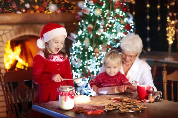 Babička a děti péct vánoční cukroví. — Stock fotografie
