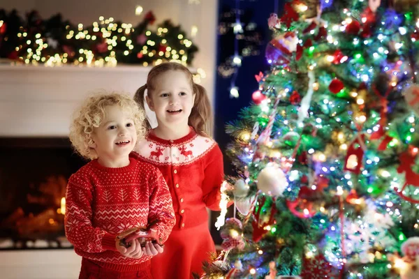 Barn på julgran. Barnen på öppen spis på Xmas eve — Stockfoto