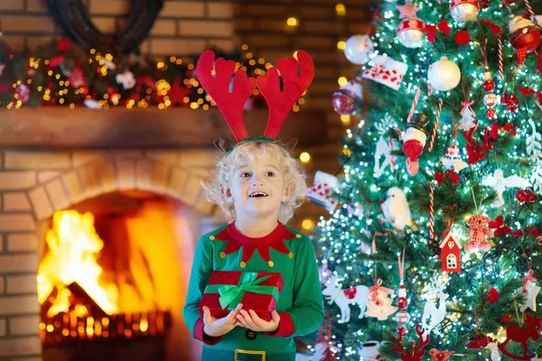 孩子在圣诞树和圣诞前夕的壁炉 — 图库照片