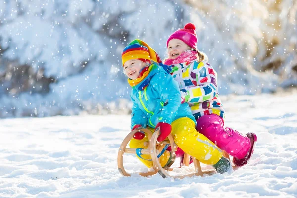 Barnen leker i snön. Vinter slädtur för barn — Stockfoto