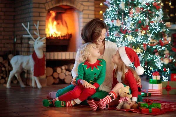 Famiglia con bambini all'albero di Natale e camino . — Foto Stock