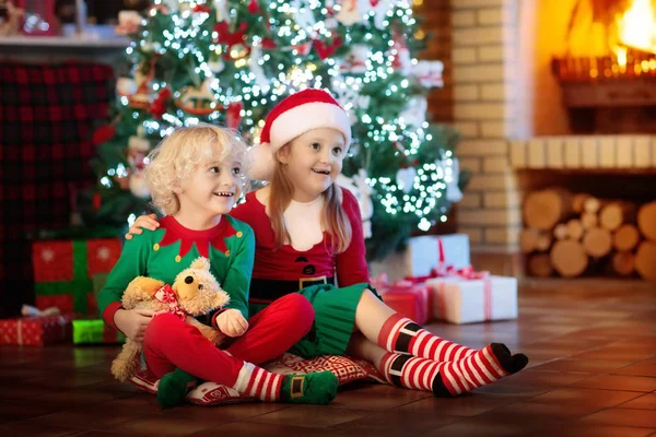 クリスマス ツリーの子。クリスマスの暖炉のそばで子供たち — ストック写真