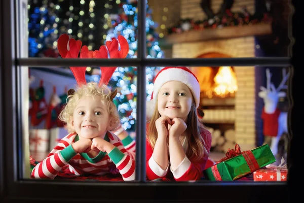 Niño en el árbol de Navidad. Niños en la chimenea en Navidad —  Fotos de Stock