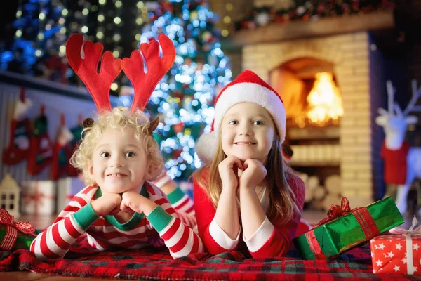 Niño en el árbol de Navidad. Niños en la chimenea en Navidad —  Fotos de Stock