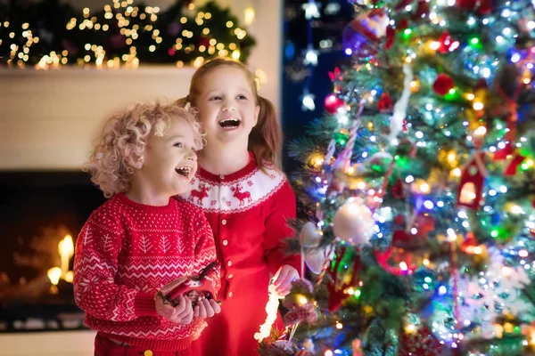 Des enfants au sapin de Noël. Enfants à la cheminée la veille de Noël — Photo