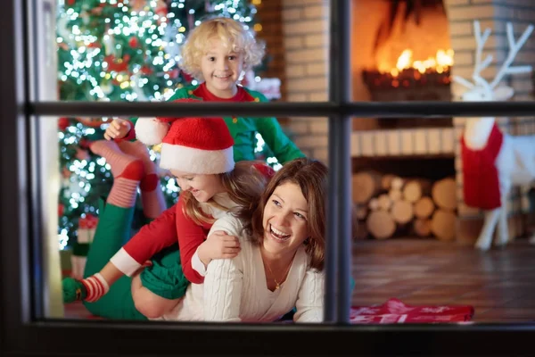 Familj med barn på julgran och öppen spis. — Stockfoto