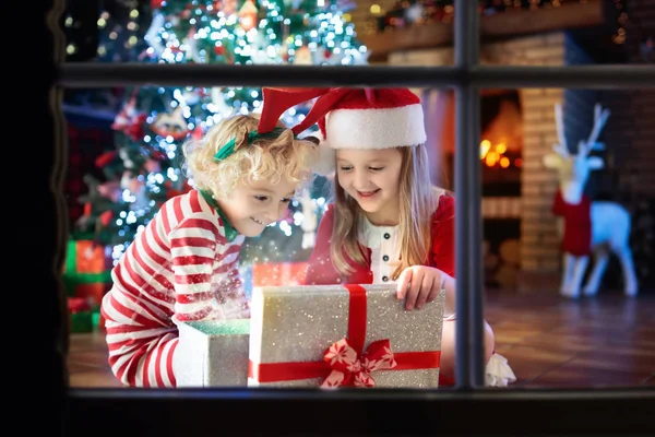孩子在圣诞树上。孩子在壁炉在圣诞节 — 图库照片