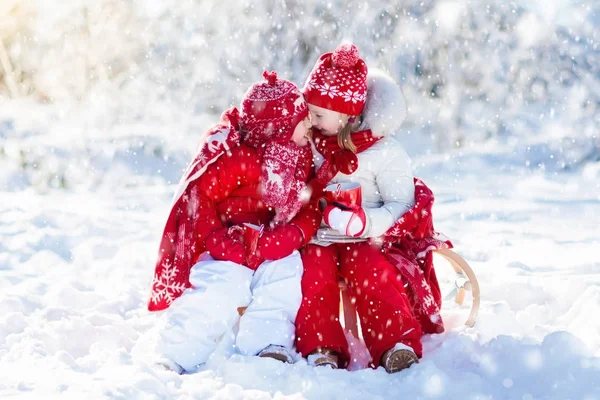 Kids sledding in winter forest. Children drink hot cocoa in snow — Stock Photo, Image