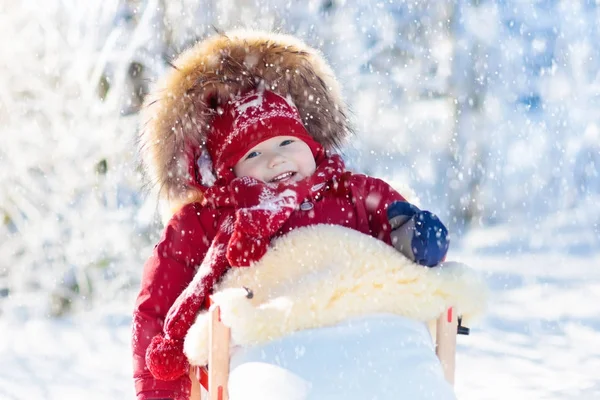 Sled e neve divertido para as crianças. Baby sledding no parque de inverno . — Fotografia de Stock