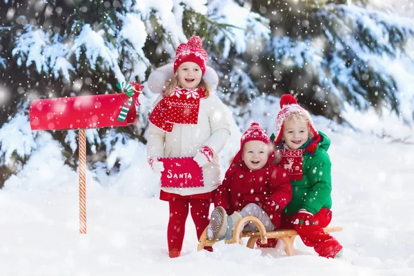 Barn med brev till Santa Jul mail box i snö — Stockfoto