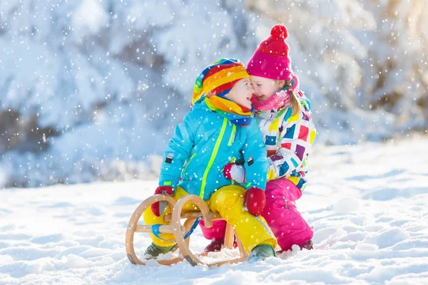 As crianças brincam na neve. Passeio de trenó de inverno para crianças — Fotografia de Stock