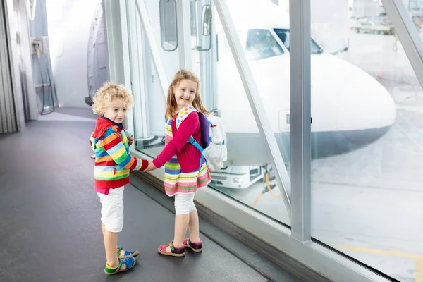Kinder reisen und fliegen. Kind im Flugzeug am Flughafen — Stockfoto