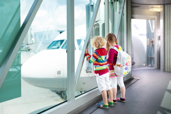 Los niños viajan y vuelan. Niño en el avión en el aeropuerto — Foto de Stock