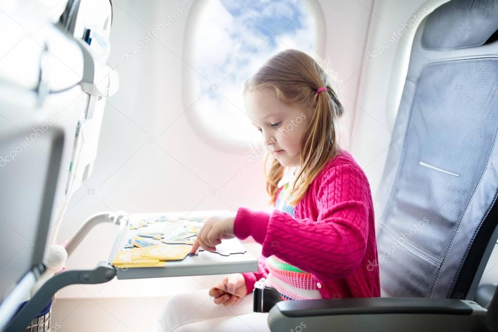 Child in airplane. Fly with family. Kids travel.