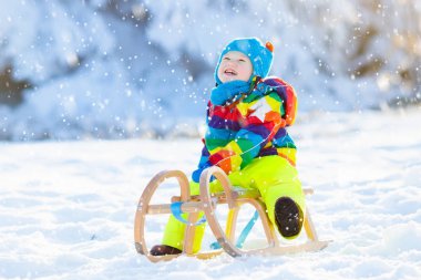 Çocuk kızağı binmek. Kızakla çocuk. Kızak ile çocuk
