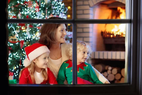 Familia con niños en el árbol de Navidad y la chimenea . —  Fotos de Stock