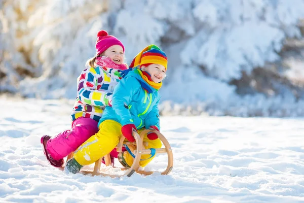 Los niños juegan en la nieve. Paseo en trineo de invierno para niños — Foto de Stock