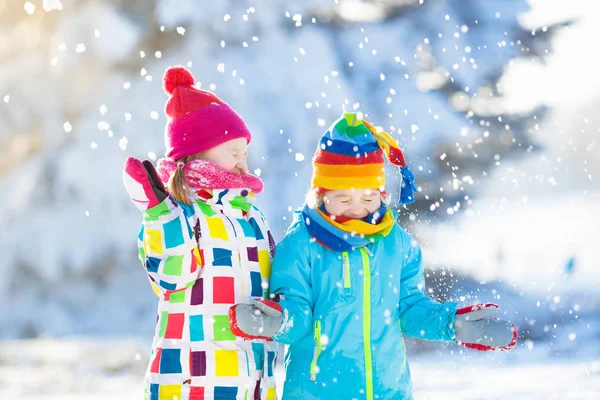 Pelea de bolas de nieve de invierno. Niños juegan en la nieve —  Fotos de Stock