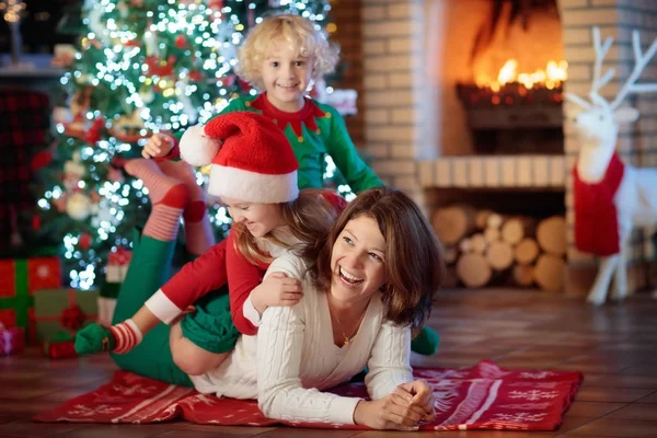 Família com crianças na árvore de Natal e lareira . — Fotografia de Stock