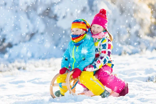 Anak-anak bermain di salju. Naik kereta salju untuk anak-anak — Stok Foto