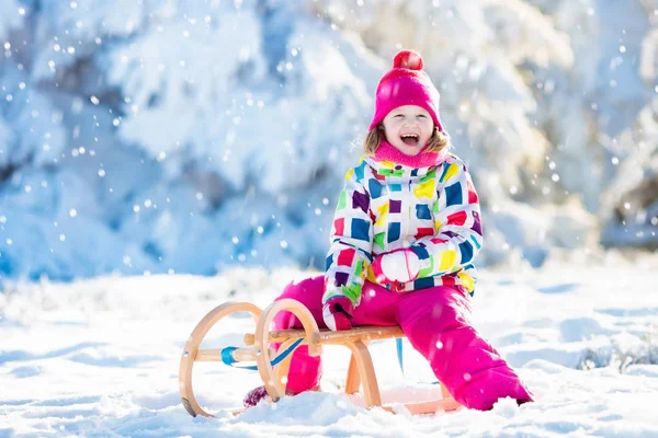 Ragazza in sella alla slitta. Slitta infantile. Ragazzo con slitta — Foto Stock