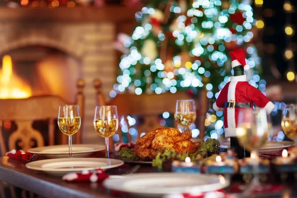 Christmas dinner at fire place and Xmas tree. — Stock Photo, Image