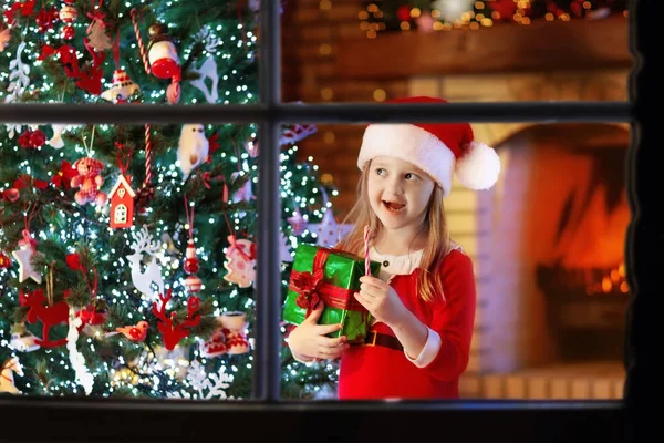 Niño en el árbol de Navidad y chimenea en la víspera de Navidad — Foto de Stock