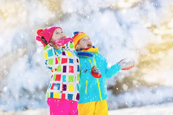 Pelea de bolas de nieve de invierno. Niños juegan en la nieve —  Fotos de Stock