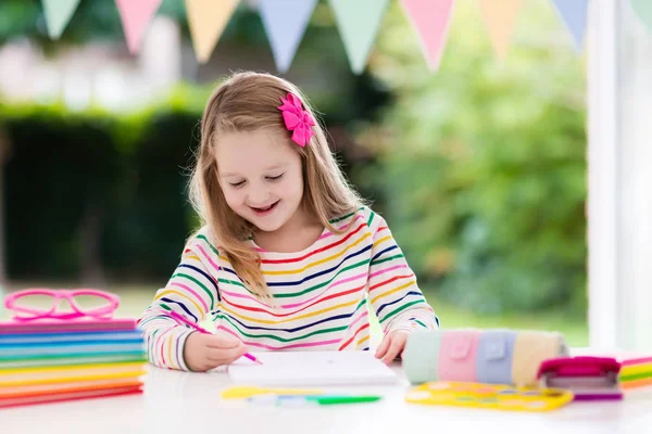 Child doing homework for school. Kids learn and paint. — Stock Photo, Image