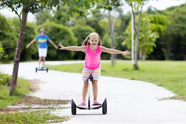 Kind op met aanwijseffect bord. Kinderen rijden op scooter — Stockfoto