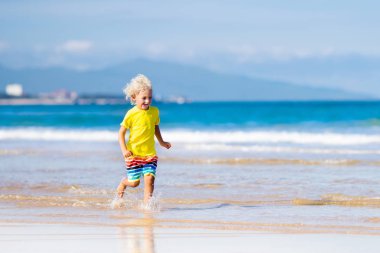 Çocuk tropik sahilde. Deniz tatil çocuklarla.