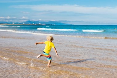 Çocuk tropik sahilde. Deniz tatil çocuklarla.